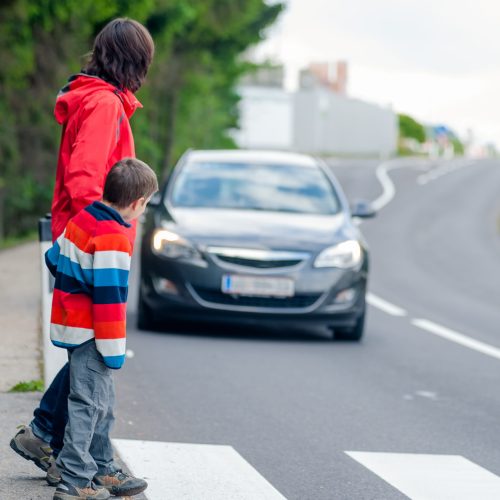 Mother and son passing a street when a car coming